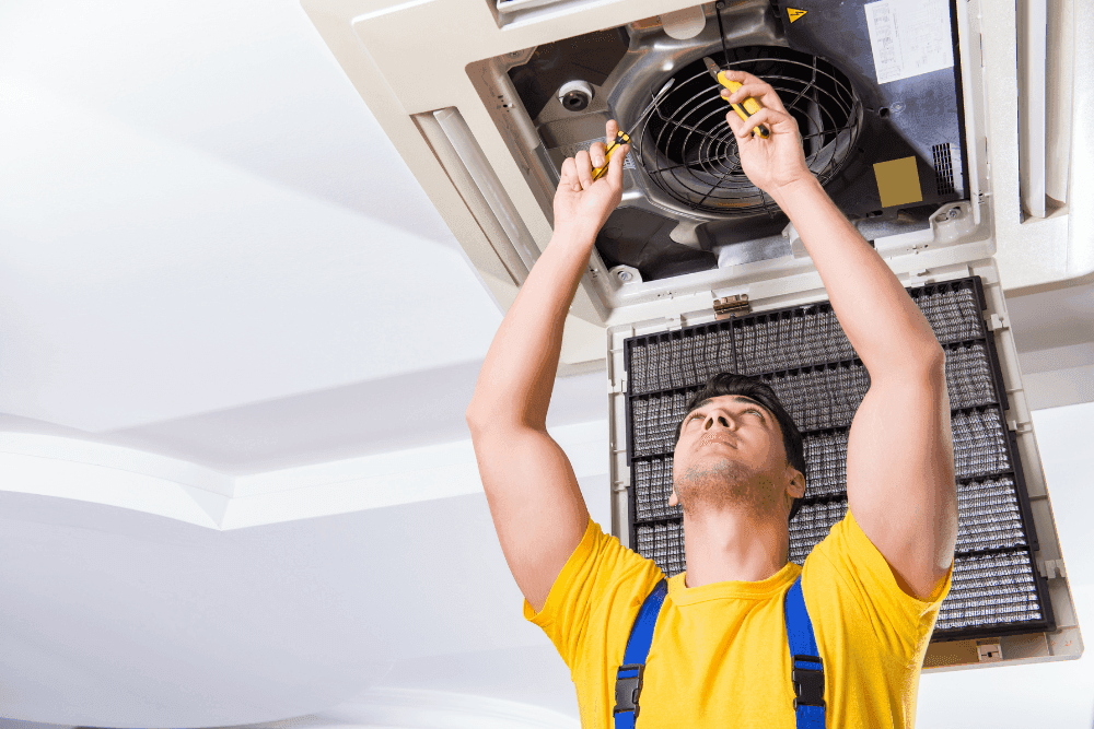 Technician inspecting a Mitsubishi Electric AC indoor unit's control board and wiring for a fault code diagnosis