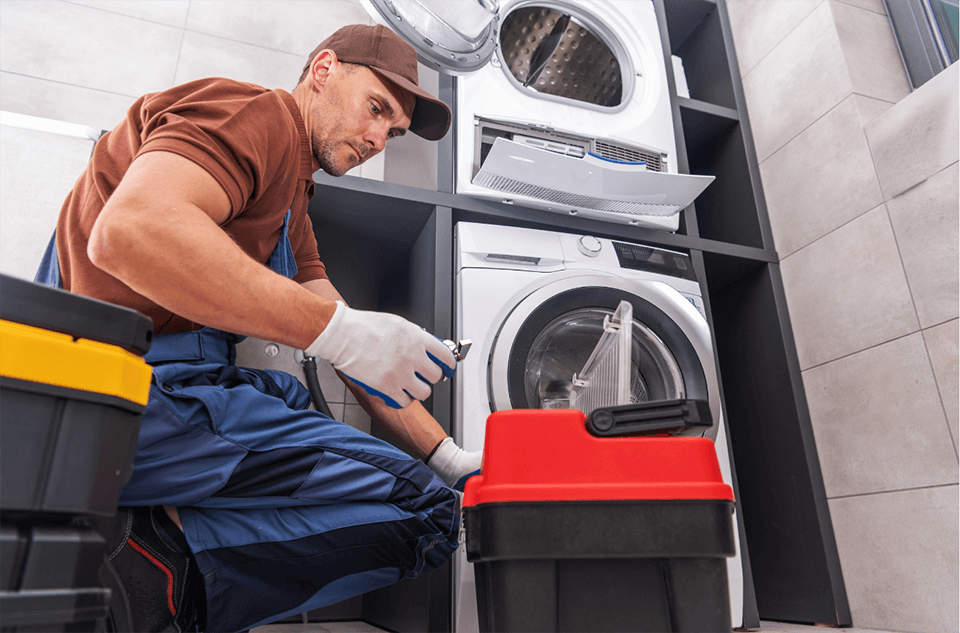 Appliance technician repairing washing machine in Dubai home